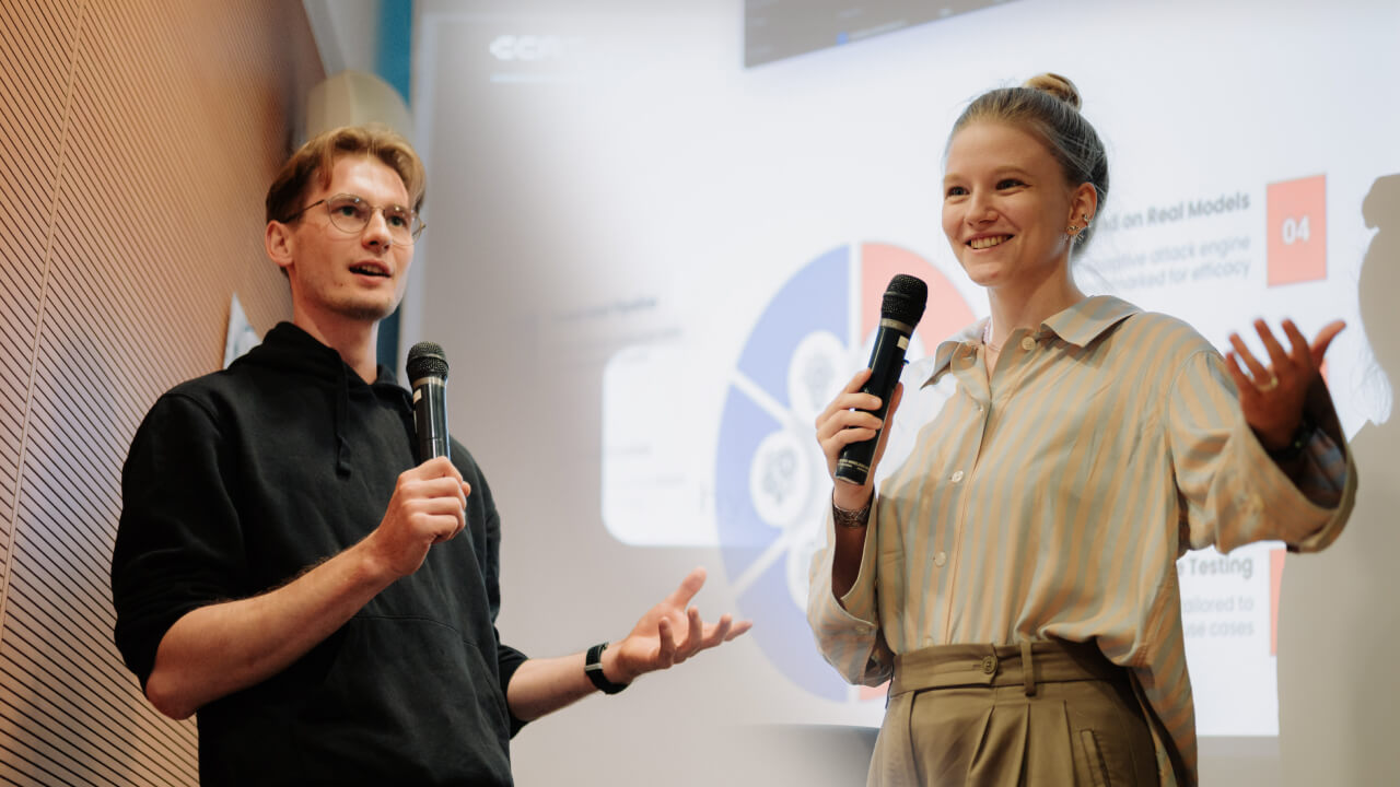 Julia Bazińska i Jan Piotrowski z mikrofonami podczas prezentacji na meetupie